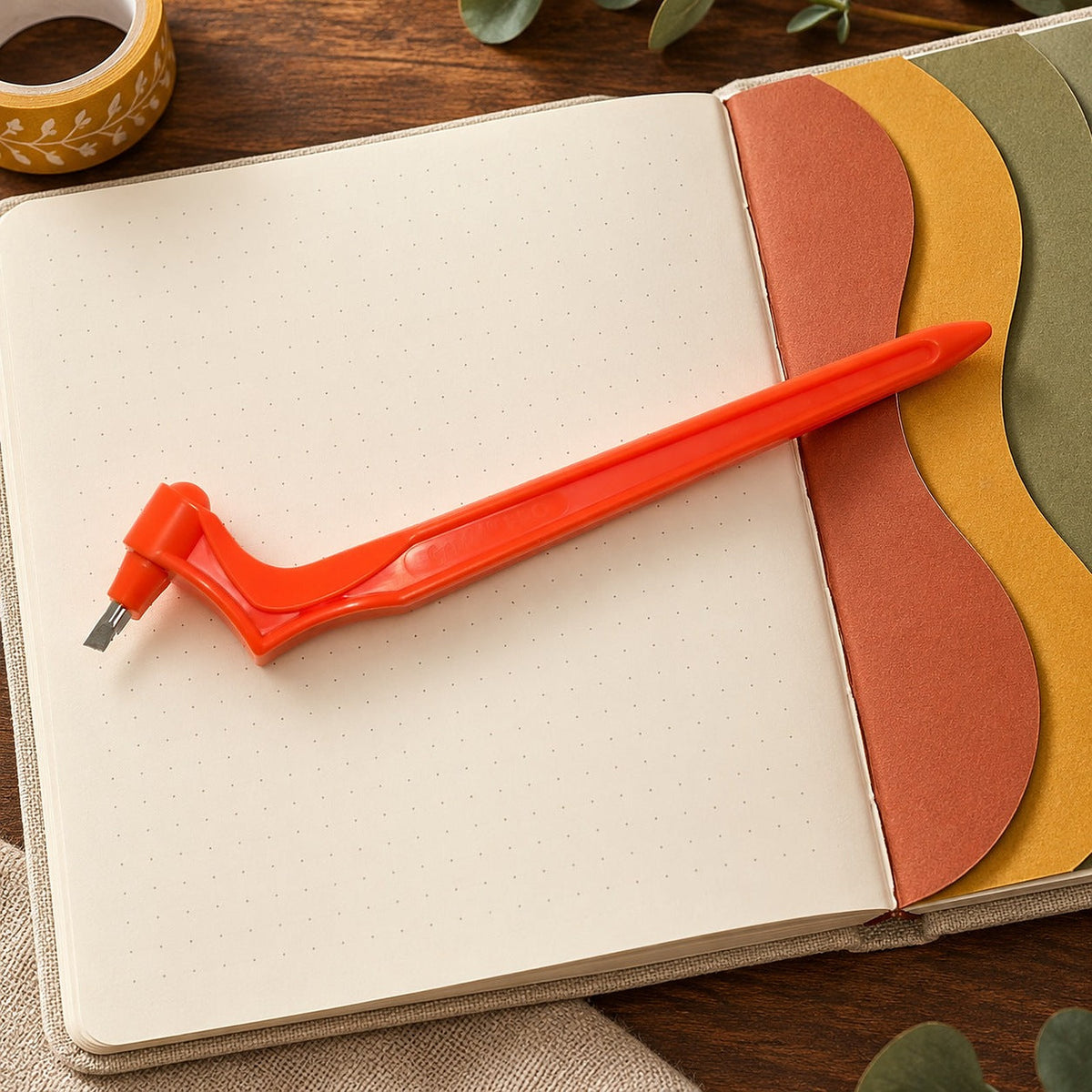 Gyro-Cut PRO posé sur un journal à points ouvert, aux pages « Dutch door » courbes